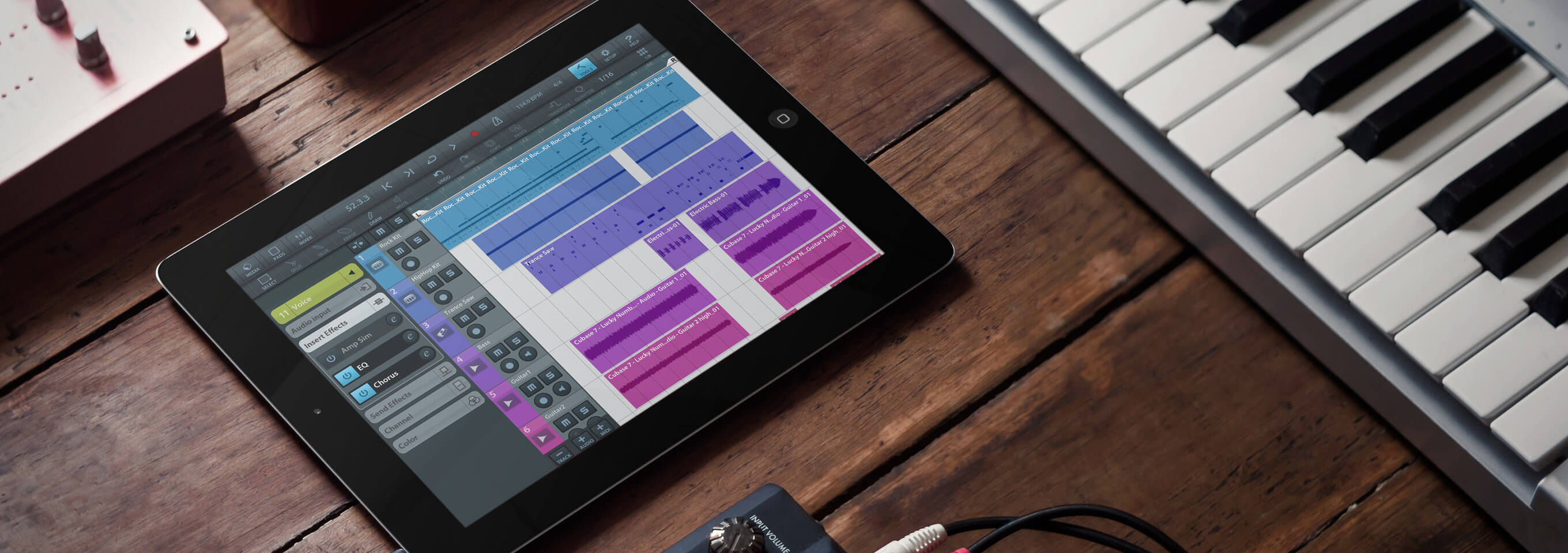 iPad Mockup on a Table Next to a Keyboard Featuring a Music Recording App in its Screen