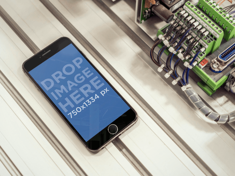 Mockup of Black iPhone 6 With Cables at Industrial Workplace