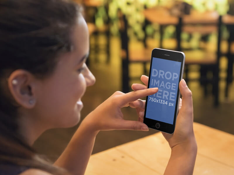 Woman Holding an iPhone 6 Mockup while Shopping