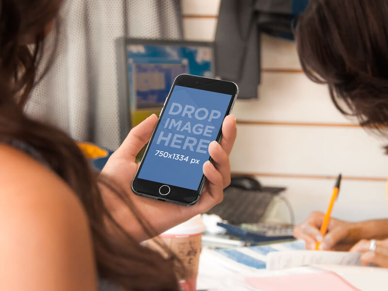 Woman Holding an iPhone 6 Mockup while Shopping