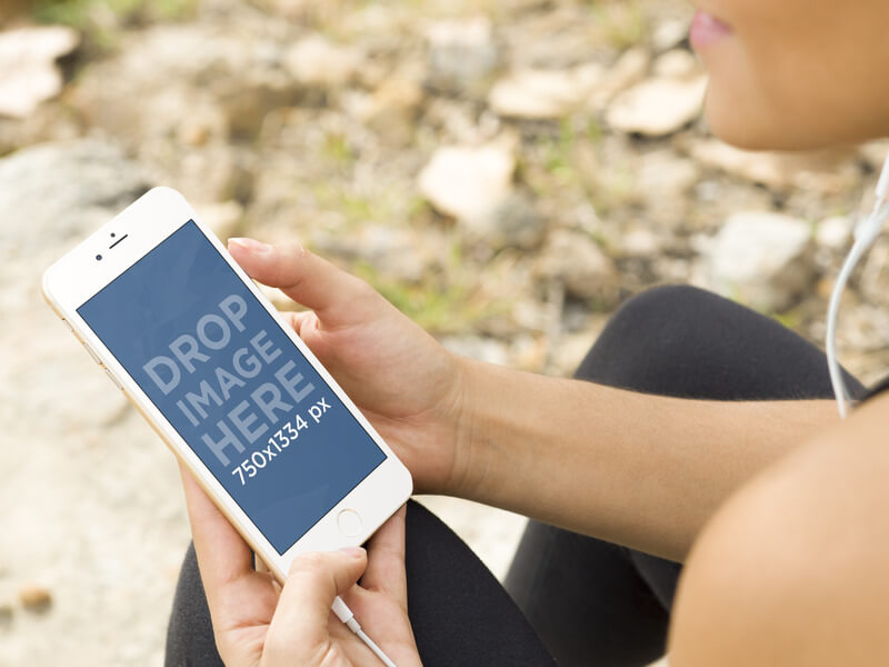 MOCKUP OF GIRL HIKING AND LISTENING TO MUSIC WITH GOLD IPHONE 6