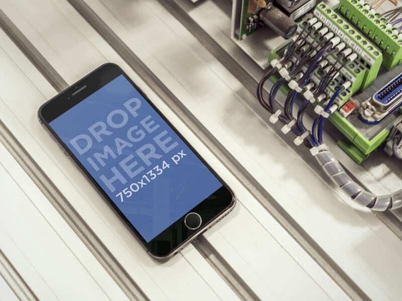 MOCKUP OF BLACK IPHONE 6 WITH CABLES AT INDUSTRIAL WORKPLACE