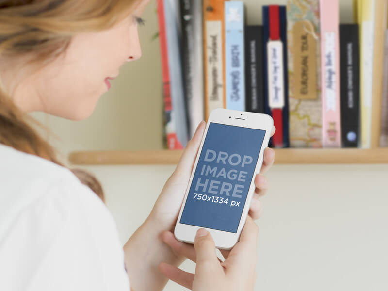 MOCKUP FEATURING A GIRL USING A WHITE IPHONE 6 BY A BOOKSHELF