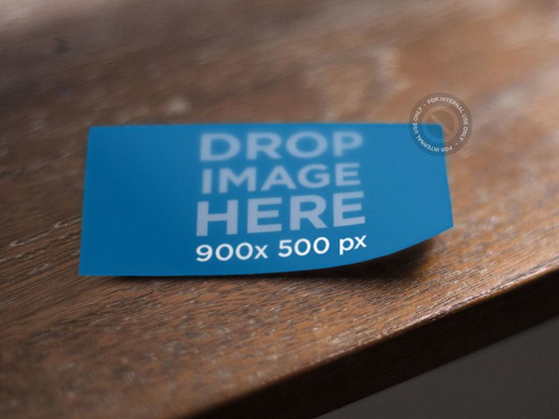 BUSINESS CARD MOCKUP LYING ON TOP OF A WOODEN TABLE