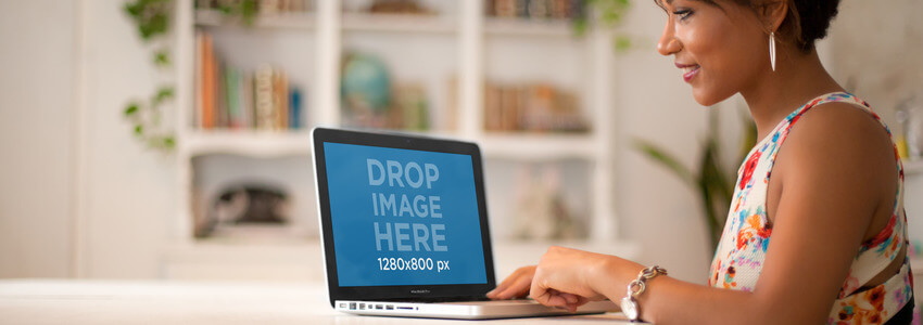 Mockup of a Girl in a Flower Dress Using a MacBook at Home