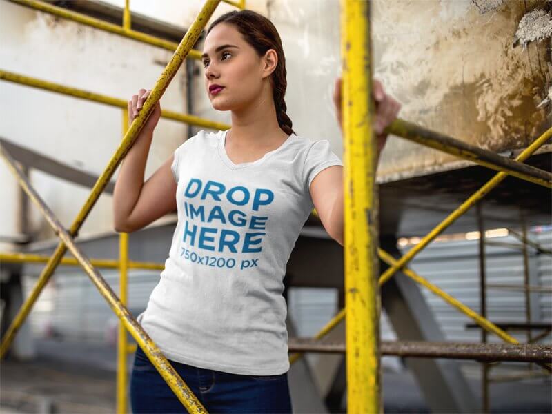 T-SHIRT MOCKUP OF A YOUNG WOMAN IN AN INDUSTRIAL SCENARIO