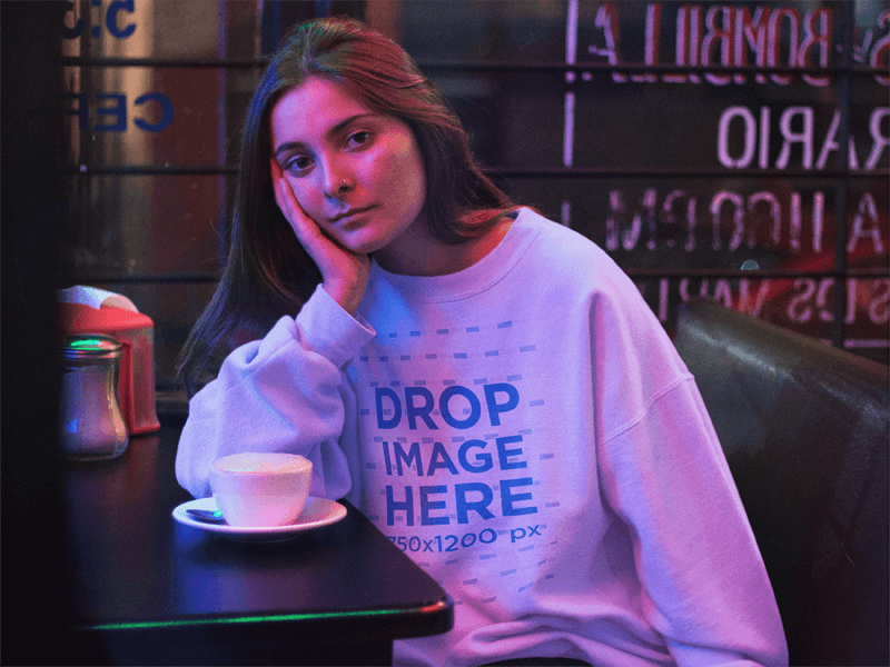 Crewneck Mockup Featuring a Lovely Girl Waiting in a Late Night Cafe