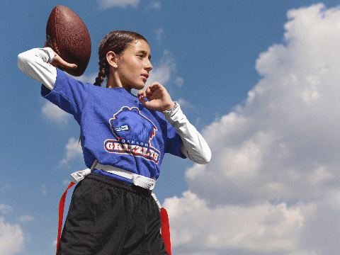 Mockup of an athletic female teen wearing different but custom football jerseys and apparel 
