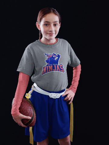 Mockup of a young little girl wearing a customized football jersey while holding a ball