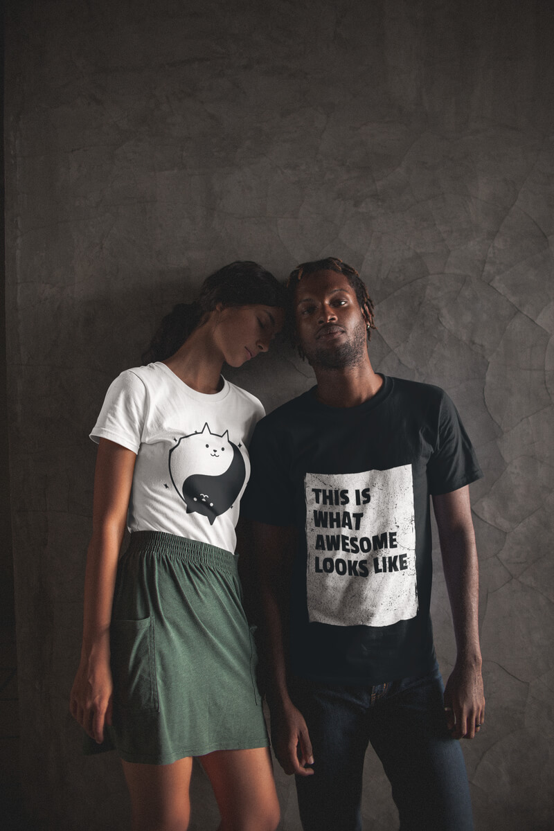 Posing Couple Wearing Interracial T Shirts Mockup Against A Gray Wall