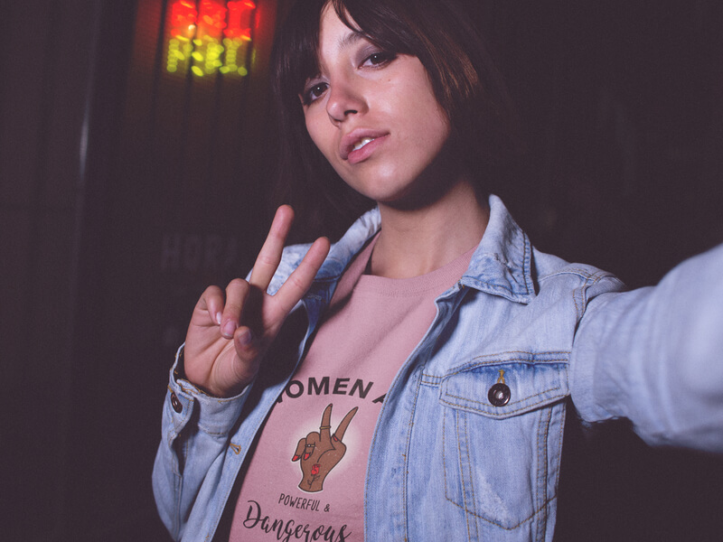 Selfie Mockup Of A Hispanic Girl Wearing A Round Neck Tshirt While Outside A Closed Japanse Food Restaurant
