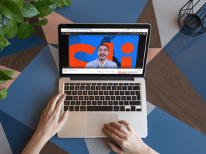 Macbook Mockup On A Multicolor Table Featuring Video