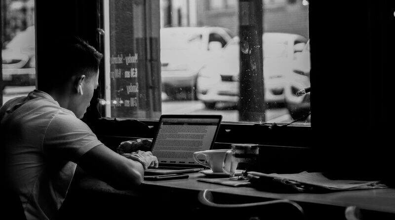 Man Writing At Cafe