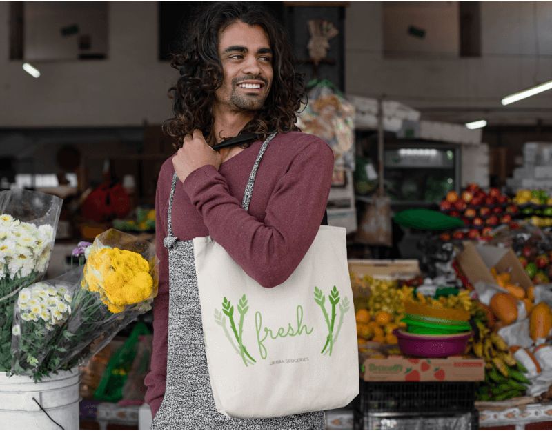 Tote Bag Mockup Of A Man With Long Hair In A Food Market