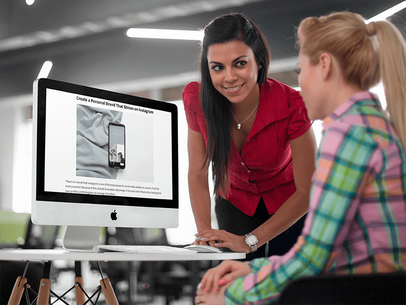 Two Young Businesswoman Chatting In Front Of An Imac Mockuppng