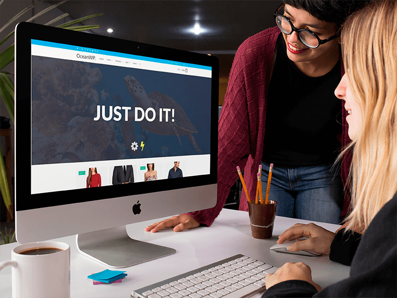 Pair Of Women Using An Imac Template While At The Office