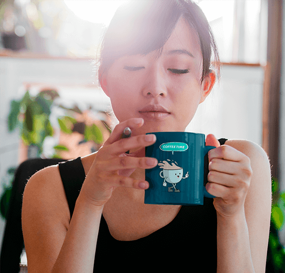 Mockup Of A Woman Drinking From An 11 Oz Coffee Mug While Working