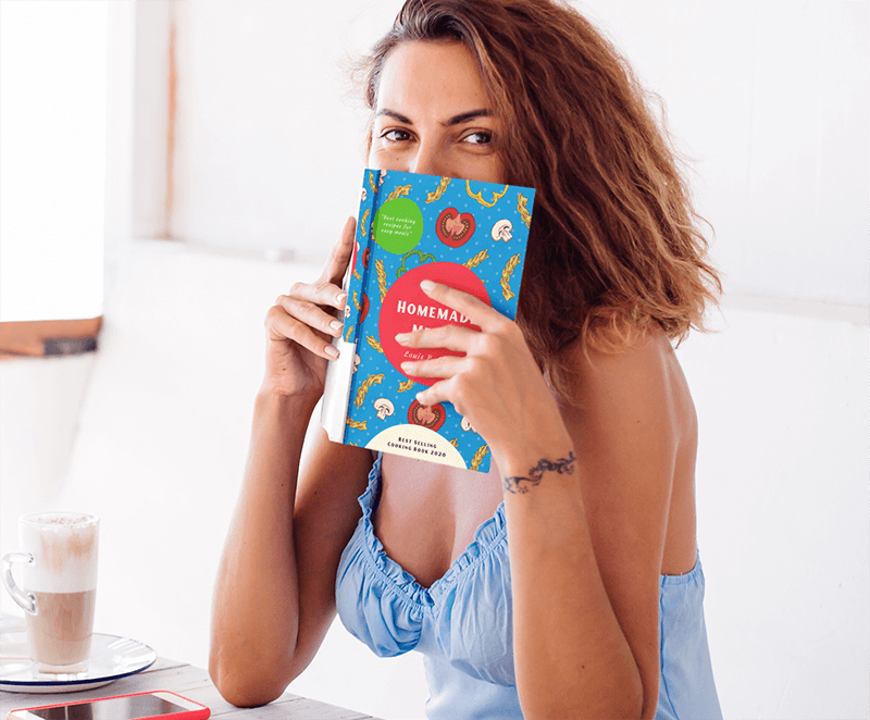 Mockup Of A Woman Holding A Book Close To Her Face