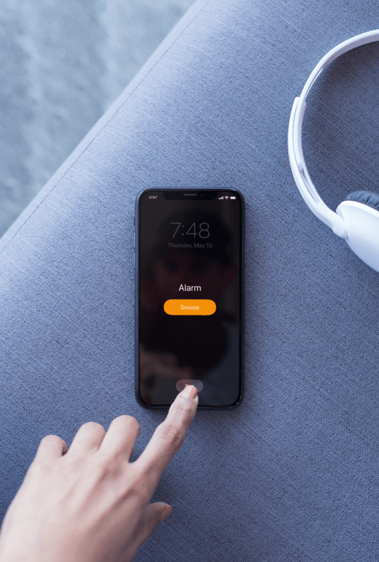 Mockup Of An Iphone X Resting On A Couch Playing A Podcast