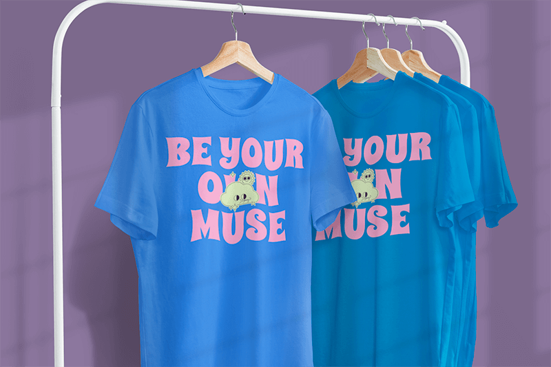 Mockup Featuring Two Customizable T Shirts Hanging From A Metal Clothing Rack