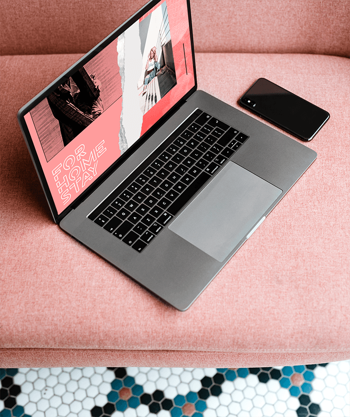 Mockup Of A Macbook Next To A Phone On A Pink Sofa