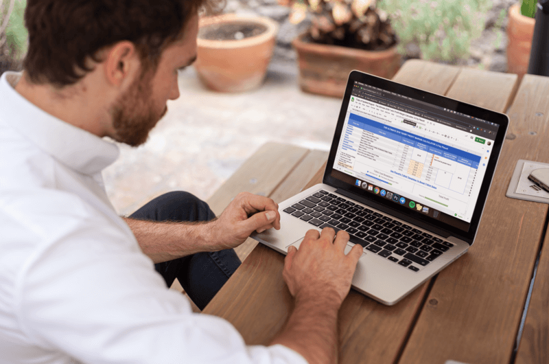 Man Using A Macbook Mockup On A Wooden Bench