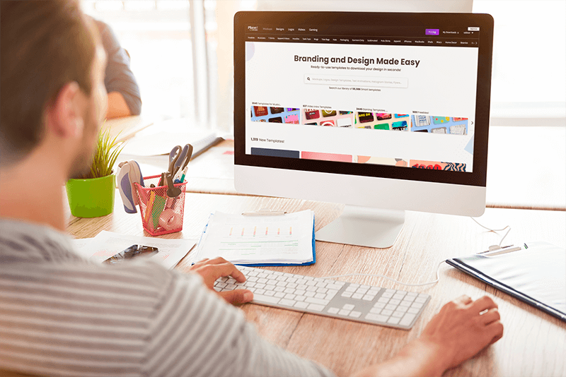 Over The Shoulder View Mockup Of A Man Using An Imac