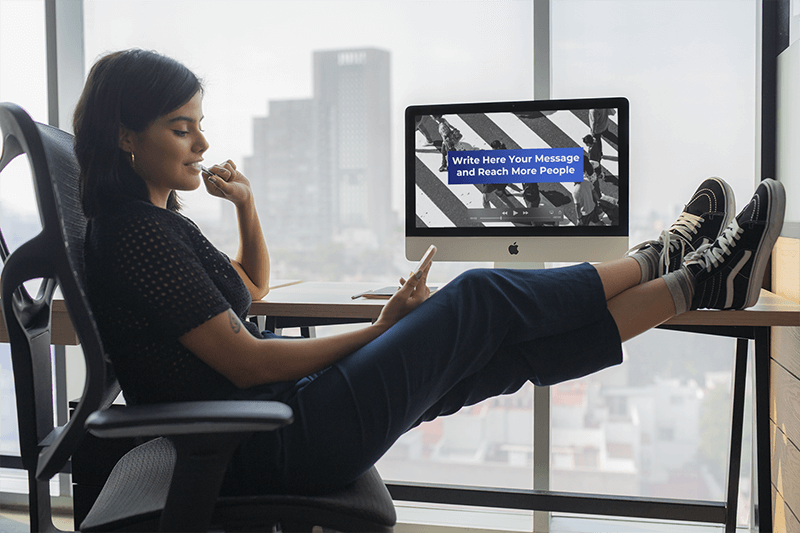 Girl Checking Her Phone At The Office Near An Imac Mockup