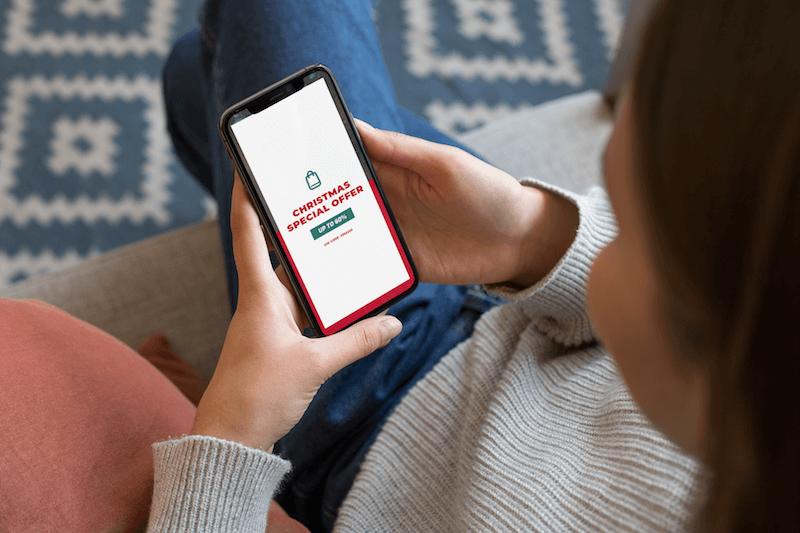 Mockup Of A Girl Sitting On A Couch Using Her Iphone