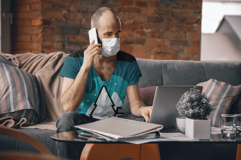 T Shirt Mockup Of A Man With A Face Mask Working From Home
