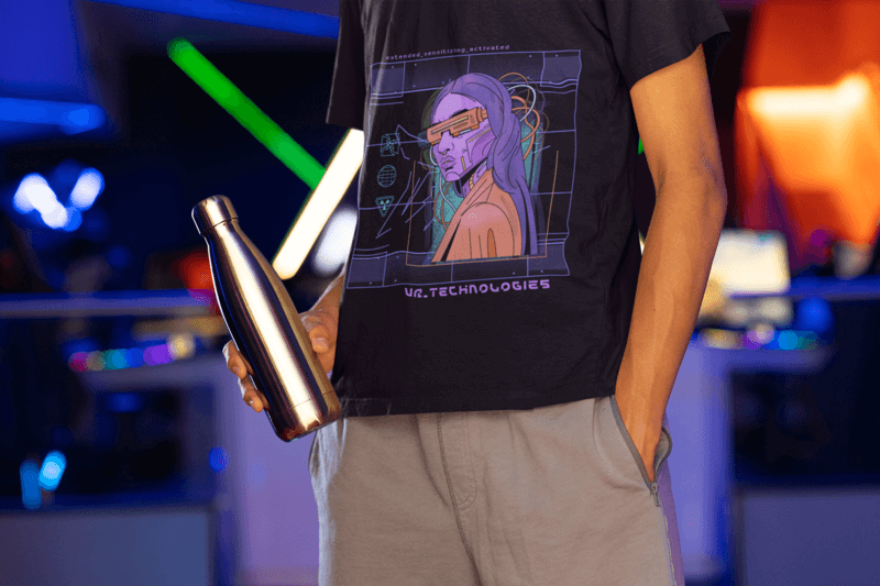 T Shirt Mockup Of A Man Holding An Aluminum Bottle At An Arcade M28554