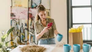 female artist taking a picture of an item to advertise on social media