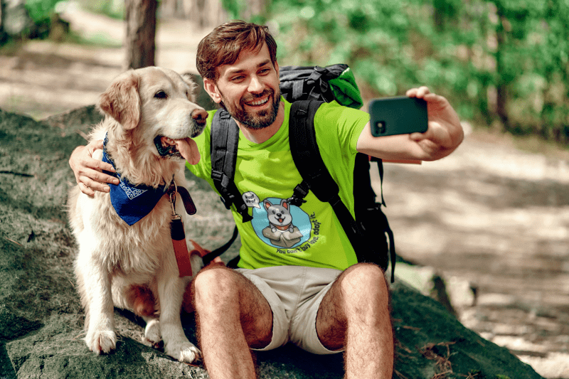 A happy hiker taking a selfie with his dog