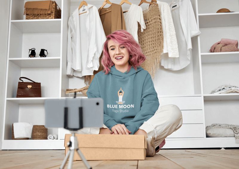 Pullover Hoodie Mockup Of A Woman With Pink Hair Recording An Unboxing Livestream