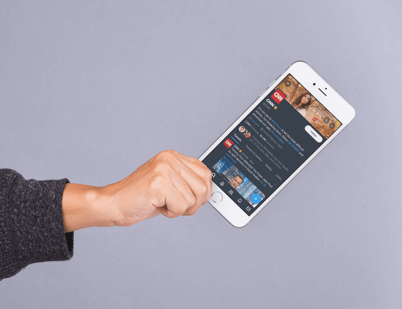 Mockup Of A Hand Holding An Iphone 8 Plus In An Angled Position Against A Gray Surface