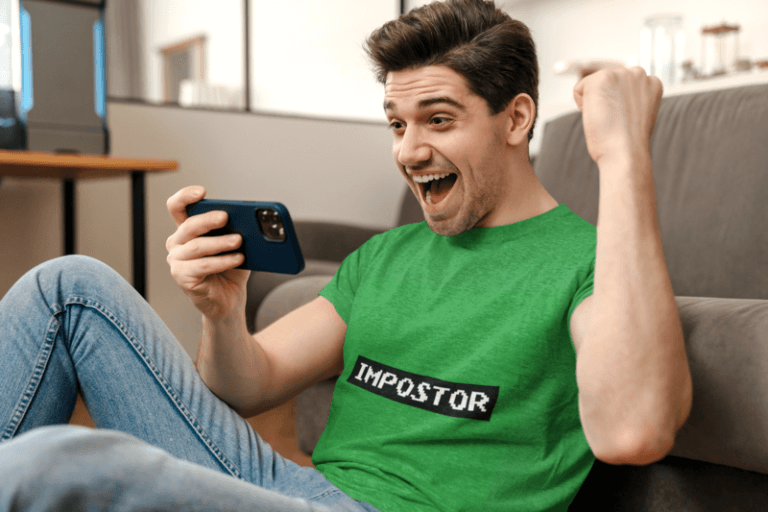 T Shirt Gaming Mockup Featuring A Man Holding A Phone And Celebrating