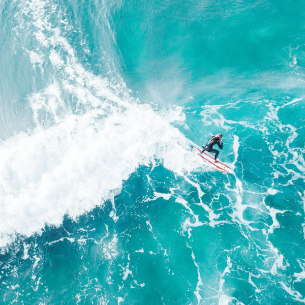 A Surfer Riding A Large Wave In A Turquoise Sea