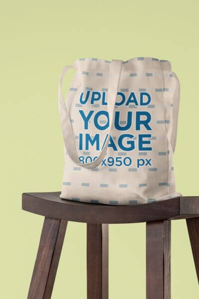 Mockup Featuring A Sublimated Tote Bag On A Wooden Stool