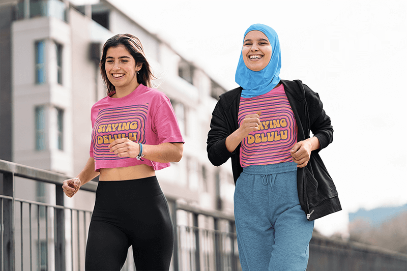 Crop Top And T Shirt Mockup Featuring Two Cheerful Women Running In The Street