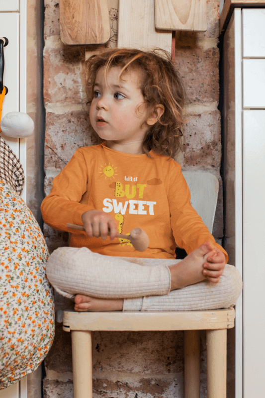 Heathered Long Sleeve Tee Mockup Featuring A Baby Girl On A Chair At Home