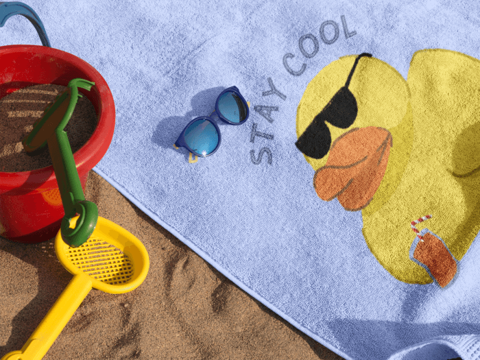 Mockup Of A Beach Towel Lying On The Beach With Accessories Near It And Sunglasses