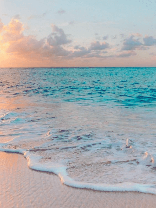 A Peaceful Beach At Sunset With Calm Waves