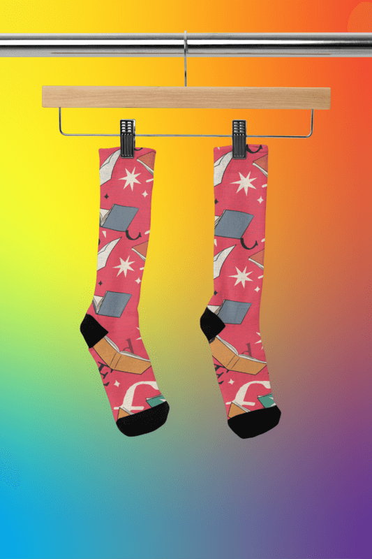 Mockup Of A Pair Of Sublimated Socks Placed On A Wooden Hanger As Inspiration For Gifts For Book Lovers