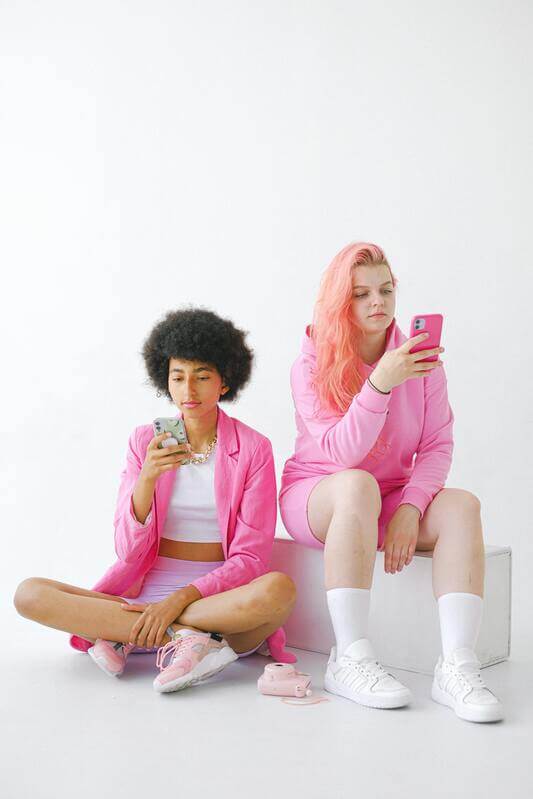 Photo Of Two Women Browsing Through Their Cellphones By Pexels