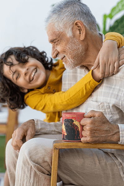 Coffee Mug Mockup Featuring A Smiling Senior Man Being Hugged By His Grandson