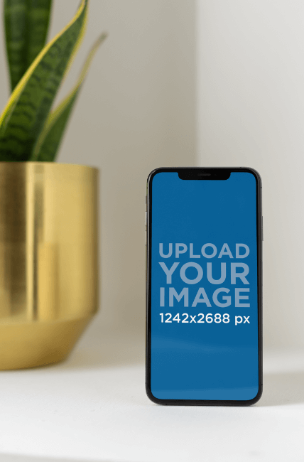 Iphone Xs Max Mockup Standing Next To An Indoor Plant