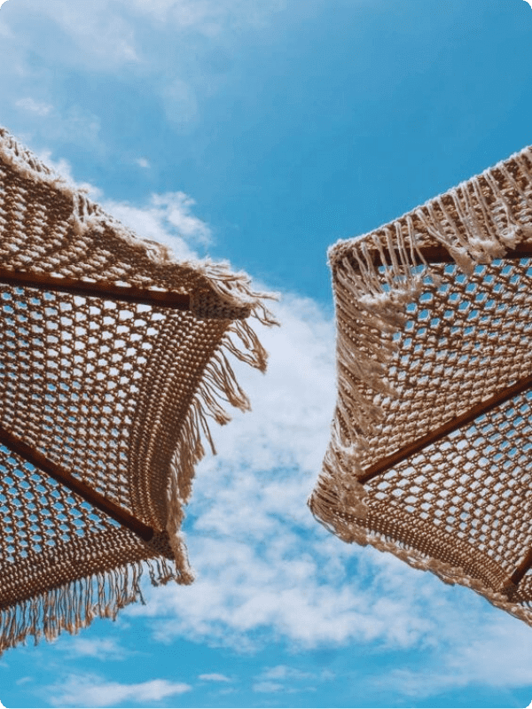 Close Up Of Two Umbrellas With The Blue Sky In The Background