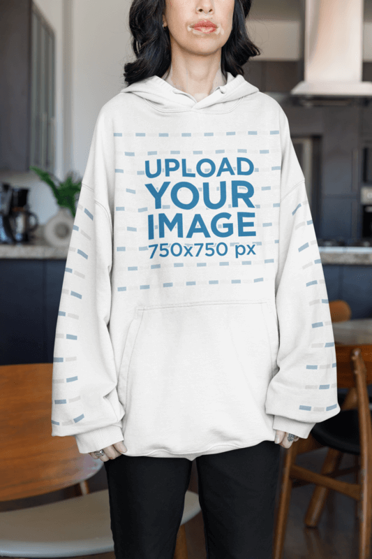 Oversized Hoodie Mockup Featuring A Cropped Face Woman Standing Near A Dining Room