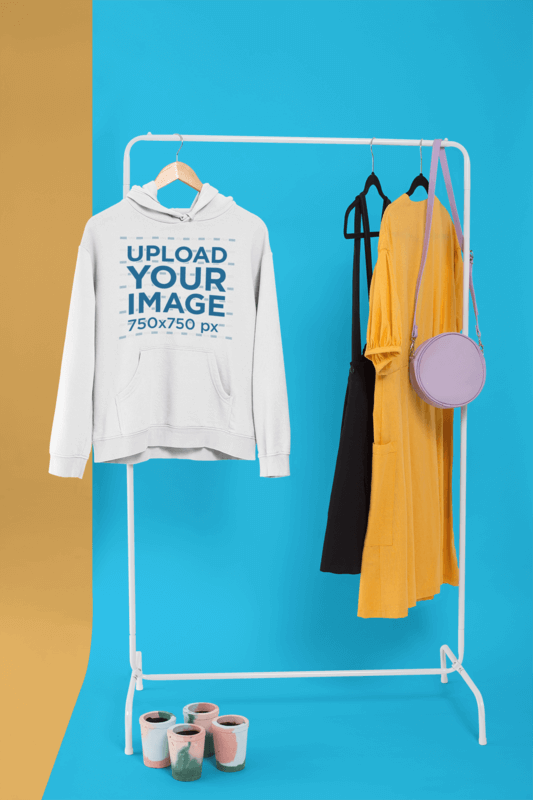 Pullover Hoodie Mockup Hanged From A Rack Along With Casual Dresses