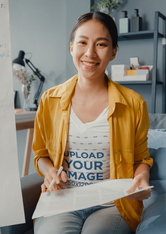 V Neck T Shirt Mockup Of A Smiling Woman Holding Some Papers